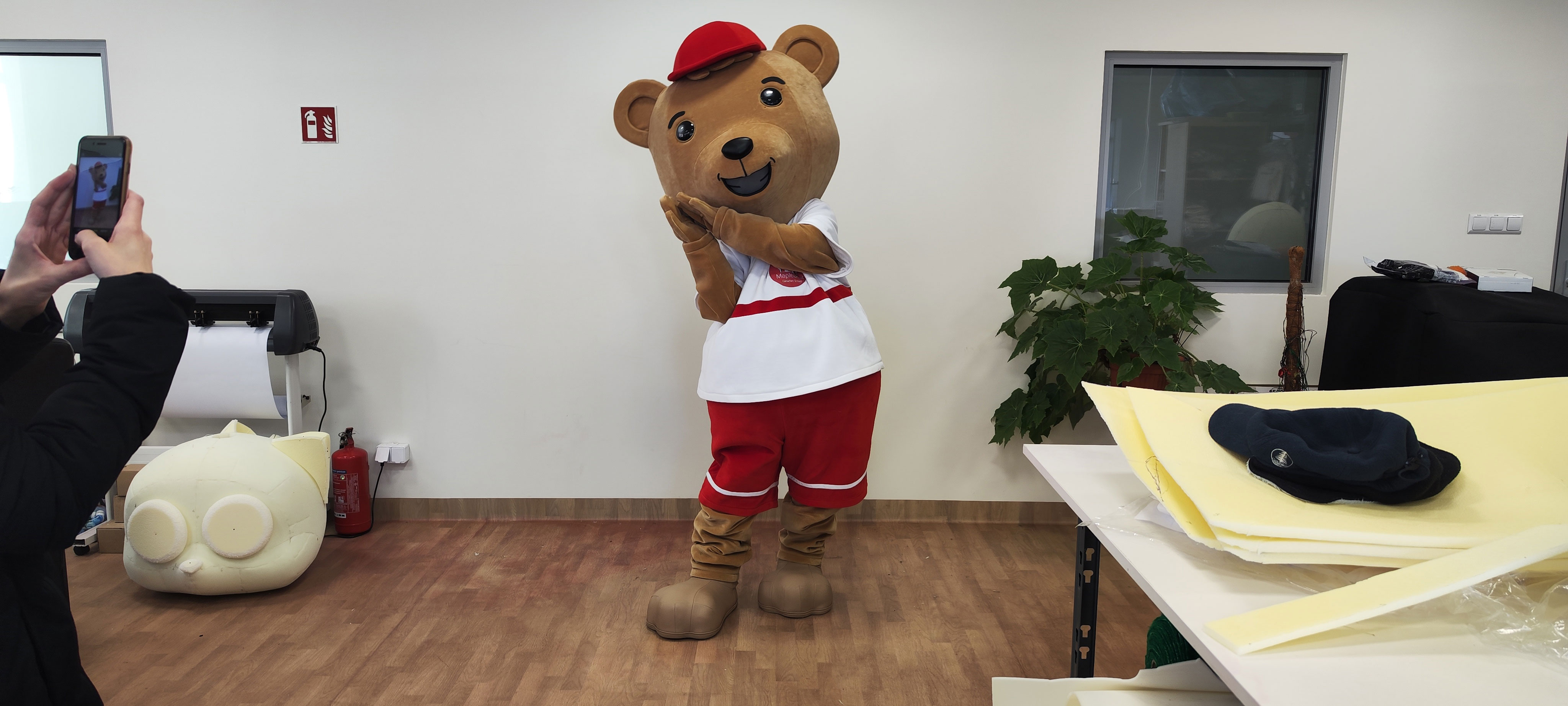 Na fotografii widnieje strój reklamowy stylizowany na postać misia pozujący do zdjęcia w siedzibie firmy Elabika